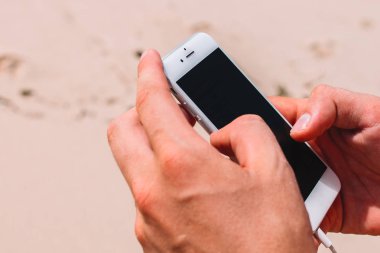 İPhone arka plan üzerinde kum erkek ellerini, yakın çekim