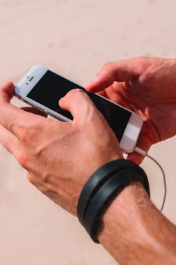 İPhone arka plan üzerinde kum erkek ellerini, yakın çekim