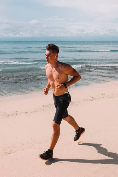 Hint Okyanusu, Endonezya, Bali kıyısında genç kas atlet trenler