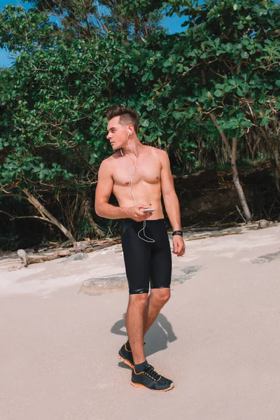 Hint Okyanusu, Endonezya, Bali kıyısında genç kas atlet trenler