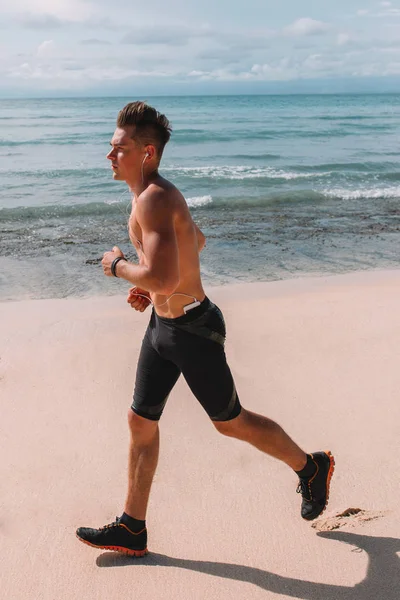 Hint Okyanusu, Endonezya, Bali kıyısında genç kas atlet trenler