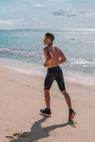 Genç atlet trenler beach Hint Okyanusu, Endonezya, Bali kas