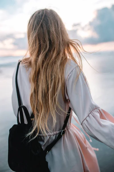 일몰, 인도네시아, 발리 동안 해변에서 분홍색 드레스에 금발 머리 소녀 — 스톡 사진