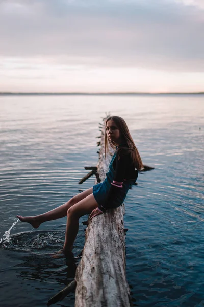 아름 다운 십 대 소녀는 숲에 호수 위에 빔에 앉아 — 스톡 사진
