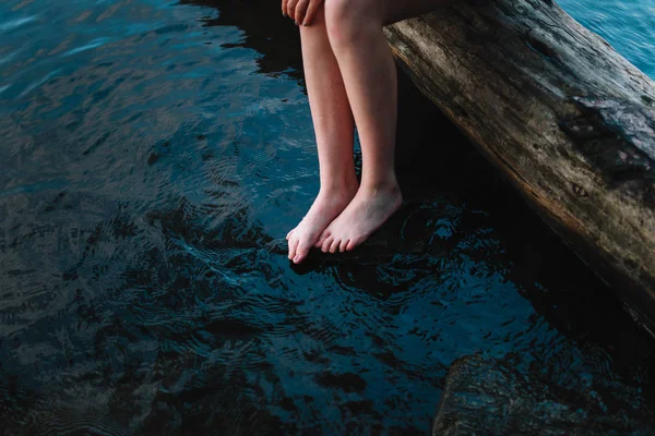 Mujer tocando el agua del lago con los dedos del pie —  Fotos de Stock