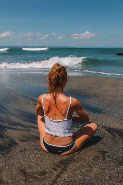 Jovem menina de cabelo vermelho praticando ioga na praia, Indonésia, Bali — Fotografia de Stock