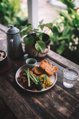 Plaka omlet, ekmek, otlar, mantar ve kuşkonmaz ahşap tablo