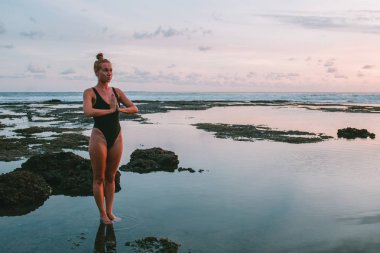 Pratik Yoga sahilde günbatımı sırasında genç çekici kız