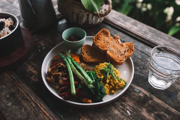 Plate with omelet, bread, herbs, mushrooms and asparagus on the wooden table — Stock Photo, Image