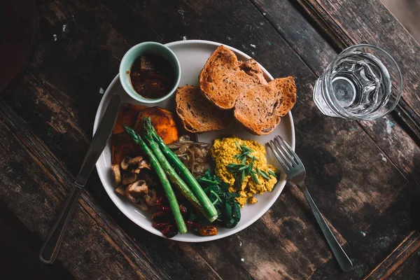 Plate with omelet, bread, herbs, mushrooms and asparagus on the wooden table — Stock Photo, Image