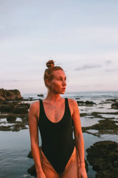 Junges attraktives Mädchen praktiziert Yoga am Strand bei Sonnenuntergang — Stockfoto