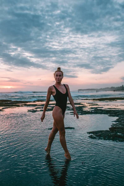 Junges attraktives Mädchen praktiziert Yoga am Strand bei Sonnenuntergang — Stockfoto