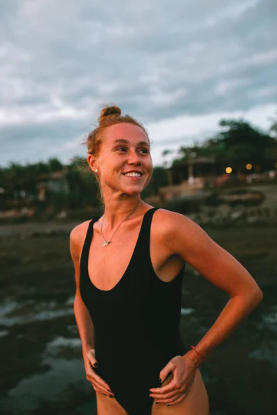 Junges attraktives Mädchen praktiziert Yoga am Strand bei Sonnenuntergang — Stockfoto