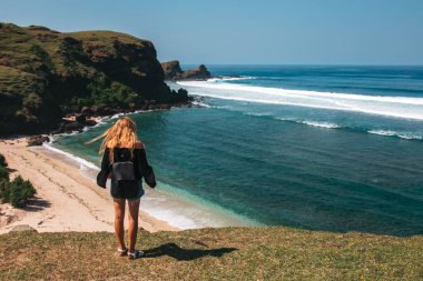 tropikal kumsalda yürüyen kadın