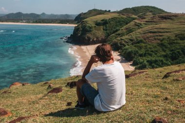tropik sahilde oturan adam