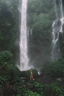  Şelalenin yanında duran kadın 