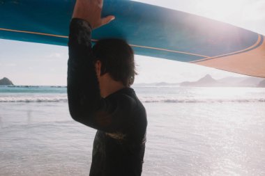 sörf tahtası taşıyan adam 