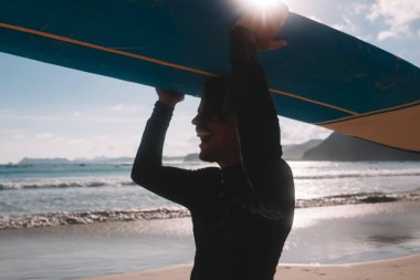 sörf tahtası taşıyan adam 