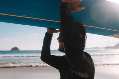 sörf tahtası taşıyan adam 