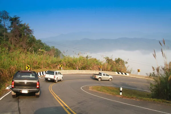Conducir en carretera curva en la montaña con la niebla del mar y azul — Foto de Stock