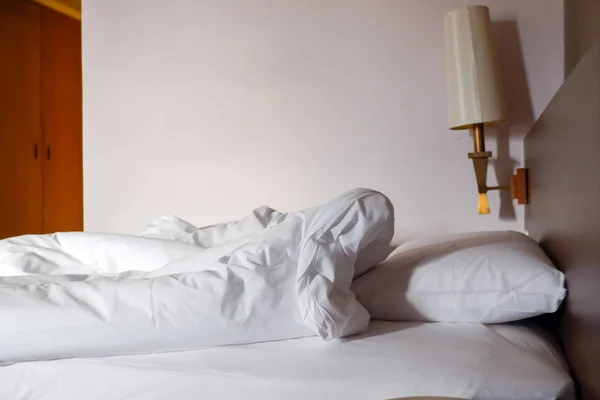 White crumpled bed sheet and messy pillows in a hotel room — Stock Photo, Image