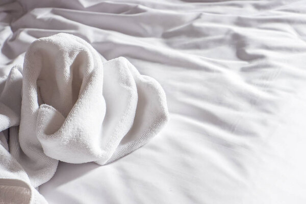 White towels used on the bed in the hotel room