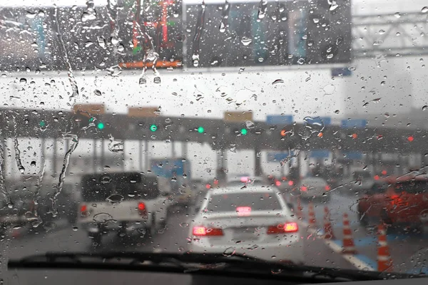 Front view of Driving with car windshield wipers in raining day on the expressway tollgate.