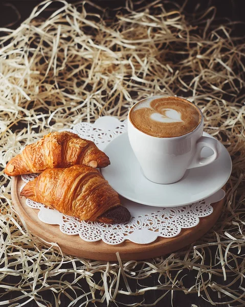 Croissants with coffee on wooden board — Stock Photo, Image