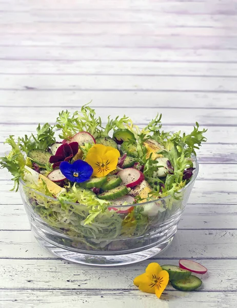 Salada orgânica decorada com flores comestíveis de pansy nas costas de madeira — Fotografia de Stock