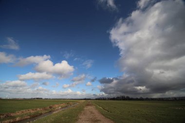 Büyük beyaz bulutlar ve Hollanda Zuidplaspolder alanlar üzerinde mavi gökyüzü