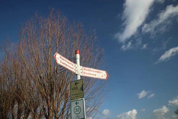 太阳与白云和蓝天在 Veenen Moerkapelle 荷兰为骑自行车的方向标志命名王尔德 — 图库照片