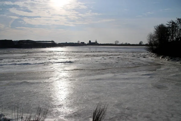 Ice flakes on river Hollandse IJssel at Moordrecht during winter in the Netherlands with reed.