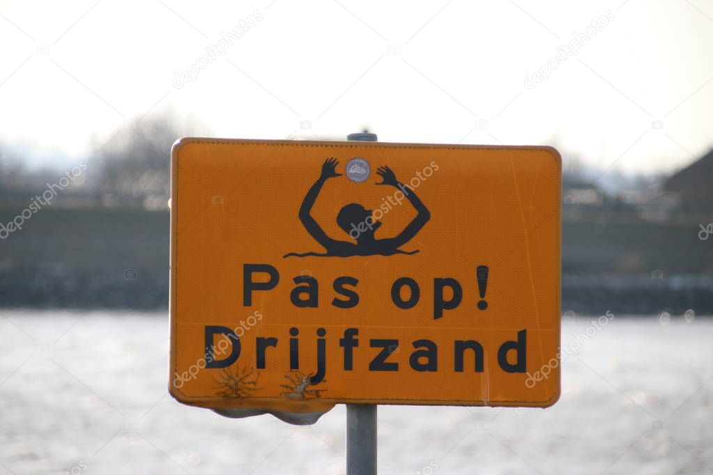 warning sign for quicksand at the Hollandse IJssel riverside.
