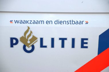 'Waakzaam en dienstbaar' çizgili ve inanışlı bir arabada Hollanda polisinden bir işaret var. Yani uyanık ve yardımsever.