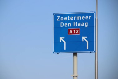 Hollanda 'daki Den Haag ve Zoetermeer' e giden A12 otobanındaki mavi yön işareti.