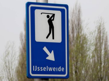 Golf oyuncusu ve okla birlikte Gouda 'daki Golfbaan Ijsselweide otoparkına yönlendirme işareti.