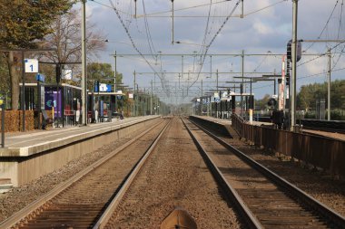 Hollanda 'daki Zwolle' a giden ufuk çizgisine kadar tren istasyonları ile Harde istasyonundaki platformlar.