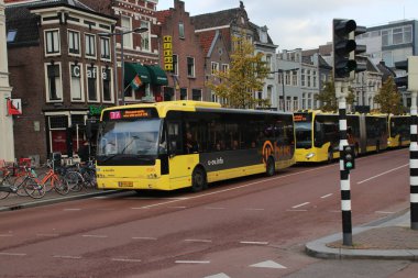 Utrecht şehir merkezinde birkaç sarı otobüs Qbuzz 'dan U-Ov' a gidiyor.