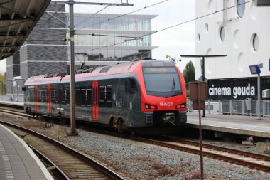 Gouda istasyonunda siyah ve kırmızı R-Net renginde flört treni Alphen aan den Rijn 'e gidiyor.