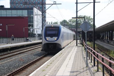 Hollanda 'daki Gouda İstasyonu platformu boyunca yerel banliyö treni