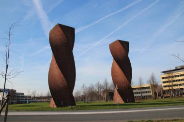 Waddinxveen 'de Wokkels adında bir yolda sanat eseri olarak iki bükülmüş çelik yığını.