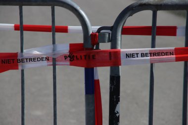 Hollanda polisinin kırmızı ve beyaz bariyer bandı suç mahallinde bir bariyer üzerinde