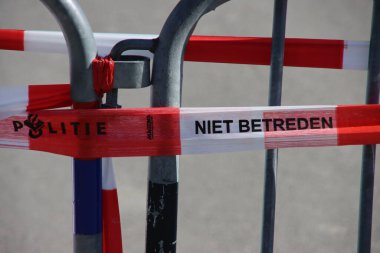 Hollanda polisinin kırmızı ve beyaz bariyer bandı suç mahallinde bir bariyer üzerinde