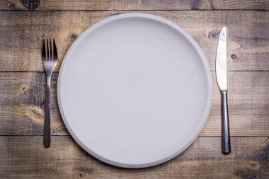 Plaka ve bıçak ve ahşap arka plan üzerinde yukarıdan çatalı