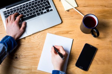 İş notları çalışma masası dizüstü bilgisayar, akıllı telefon ve o taking
