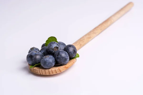 Blueberries on wooden spoon on white background — Stock Photo, Image
