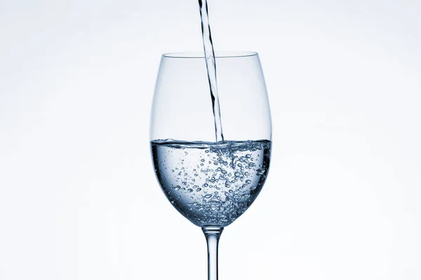 Wasser in Glas auf weißem Hintergrund gegossen — Stockfoto