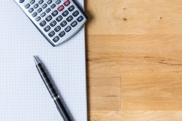 Bureau met opmerking stootkussen, rekenmachine en biro op houten tafel — Stockfoto