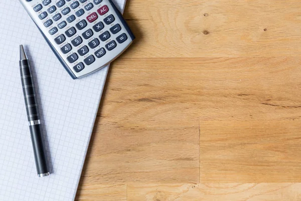 Bureau met opmerking stootkussen, rekenmachine en biro op houten tafel — Stockfoto