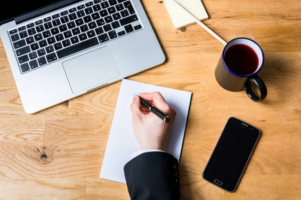 Het maken van zakelijke notities op Bureau met laptop, smartphone en o — Stockfoto